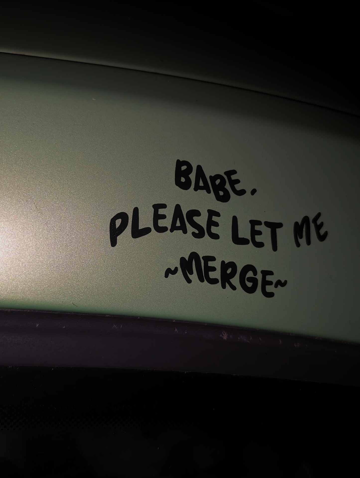 Text 'Babe, please let me merge' written on a light surface.