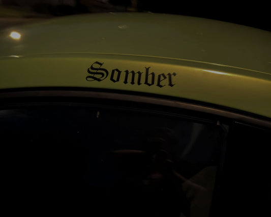 Car with 'Somber' decal on a dark background