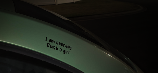 Car window with a humorous text sticker in a dark setting
